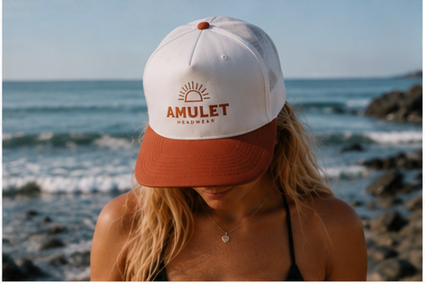 Woman wearing the Amulet Solar trucker cap on a Pacific beach