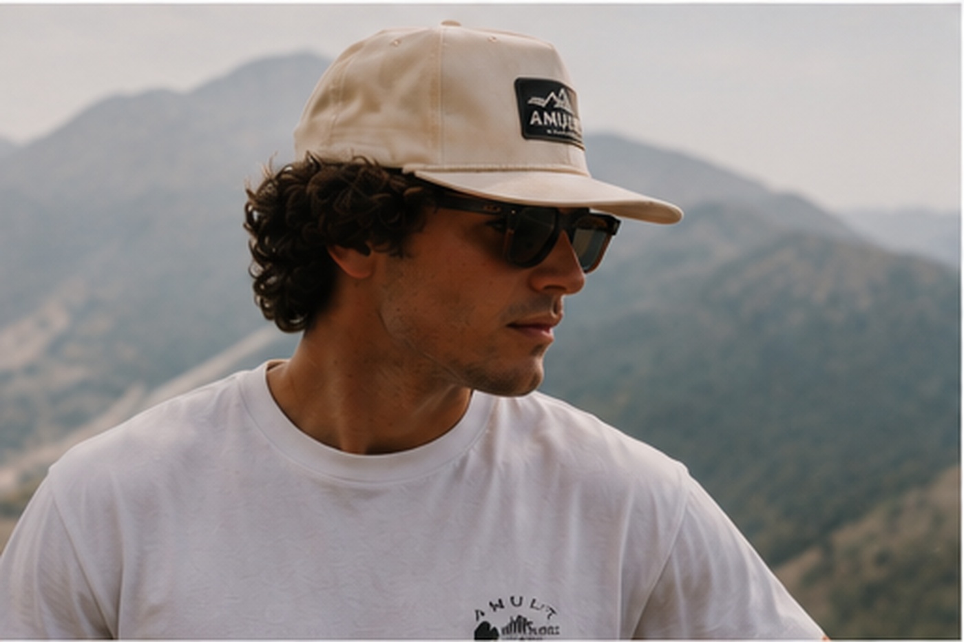 Person in cream Amulet cap on a mountain ridgeline